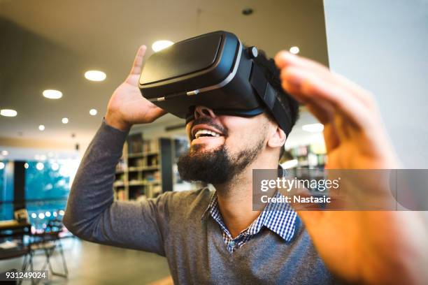 young male student using vr headset for learning - virtual library stock pictures, royalty-free photos & images