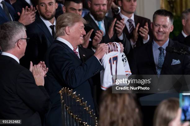 President Donald Trump holds up a jersey he received from the Houston Astros, during the celebration of the Astros' World Series Championship, in the...