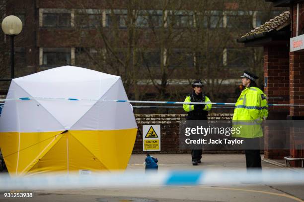 Police officers stand guard by a forensics tent over a pay and display machine in a Sainsbury's car park as investigations continue into the...