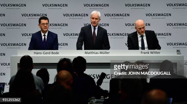 Matthias Mueller , CEO of German car maker Volkswagen , is flanked by VW's CFO Frank Witter and board member Hans-Gerd Bode as he speaks during his...