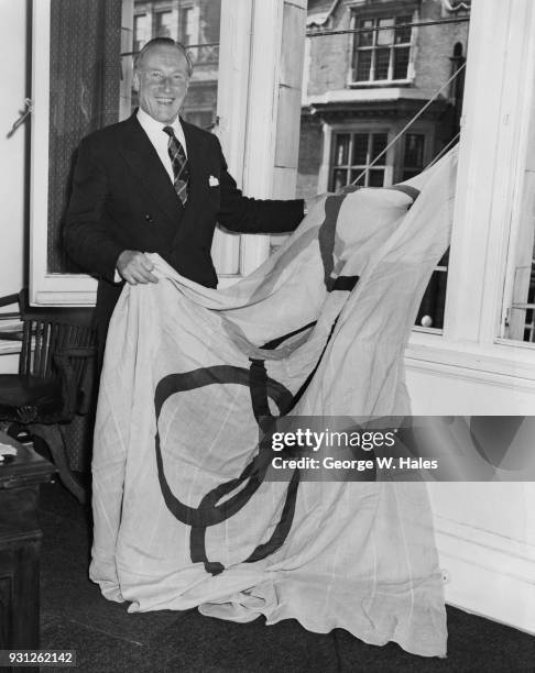 British rower Jack Beresford hoists the Olympic flag at the London offices of the British Olympic Association, on the day that the 1960 Olympic Games...