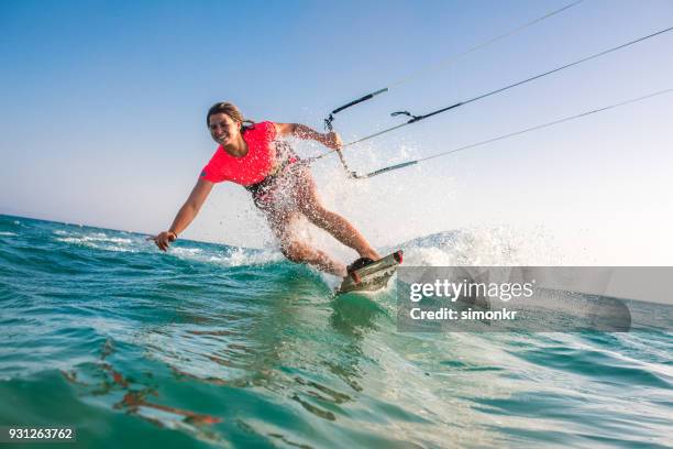 mujer haciendo kitesurf - kiteboarding fotografías e imágenes de stock