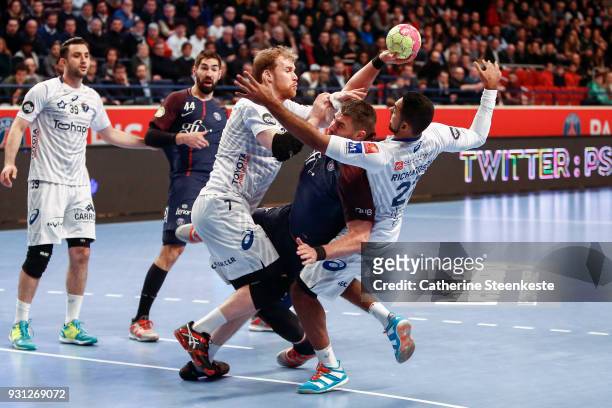 Luka Karabatic of Paris Saint Germain is trying to shoot the ball against Jonas Truchanovicius of Montpellier Handball and Melvyn Richardson of...