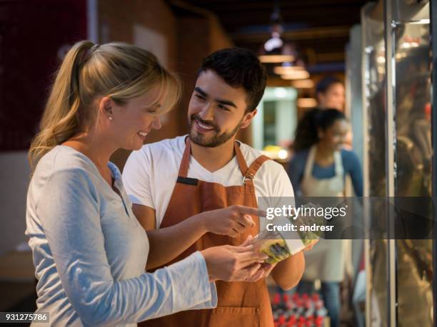 alegre vendedor sugiriendo una nueva ensalada a un cliente hermoso ambos sonriendo - friendly salesman fotografías e imágenes de stock