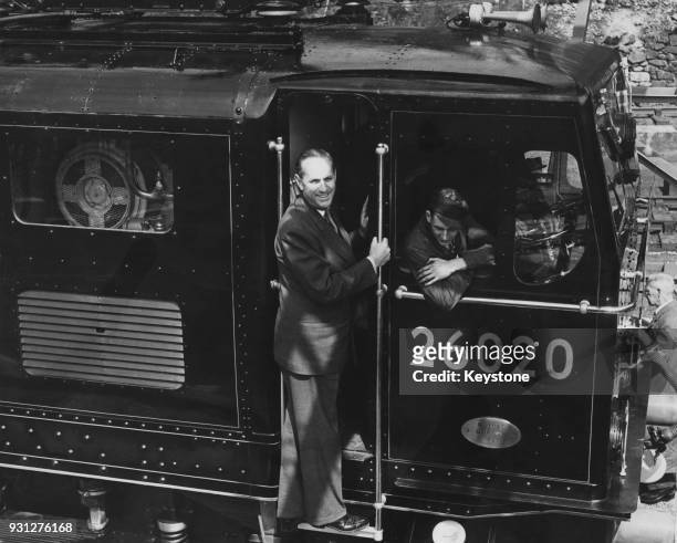 British Conservative politician Alan Lennox-Boyd , the Minister for Transport and Civil Aviation, rides on the footplate of the first train to travel...