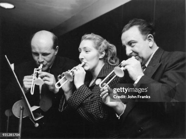 From left to right, Joseph Beachus, composer Madeleine Dring and opera singer Owen Brannigan rehearse on their tiny instruments for an April Fool's...