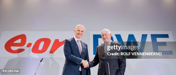 Rolf Martin Schmitz , chairman of German energy supplier RWE, and Johannes Teyssen, CEO of German utility company EON, shake hands at the beginning...