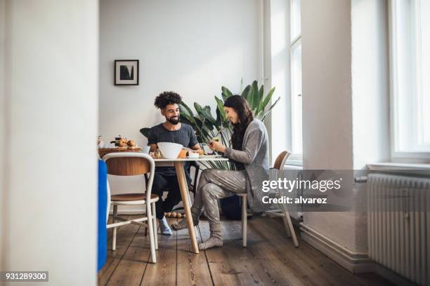 lächelnde junge paar frühstücken zu hause - couple breakfast stock-fotos und bilder