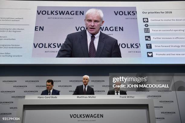 Matthias Mueller , CEO of German car maker Volkswagen , is flanked by VW's CFO Frank Witter and board member Hans-Gerd Bode as he speaks during his...