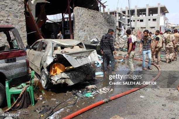 Yemenis gather near the scene of an explosion resulting from a suicide bombing claimed by the Islamic State group which hit UAE-trained Yemeni troops...