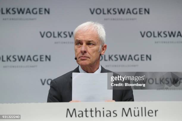 Matthias Mueller, chief executive officer of Volkswagen AG , holds a document during a news conference at the automaker's annual media conference in...