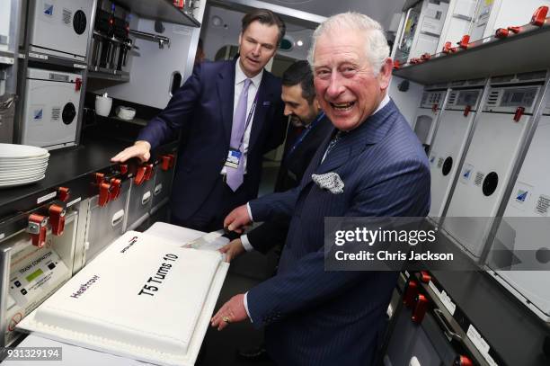 Prince Charles, Prince of Wales cuts a cake celebrating 10 years of Terminal 5 onboard a British Airways 787 aircraft during a visit to Heathrow...