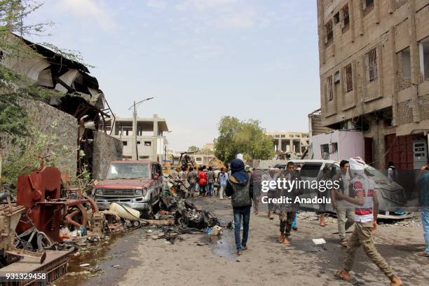 Yemeni people inspect wreckages after a booby-trapped car hit a mess hall serving Yemeni forces trained by the United Arab Emirates in Sheikh Othman...