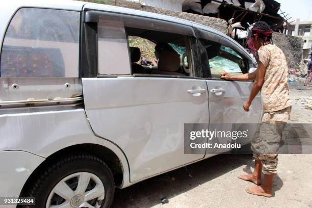 Yemeni man inspects wreckages of a car after a booby-trapped car hit a mess hall serving Yemeni forces trained by the United Arab Emirates in Sheikh...