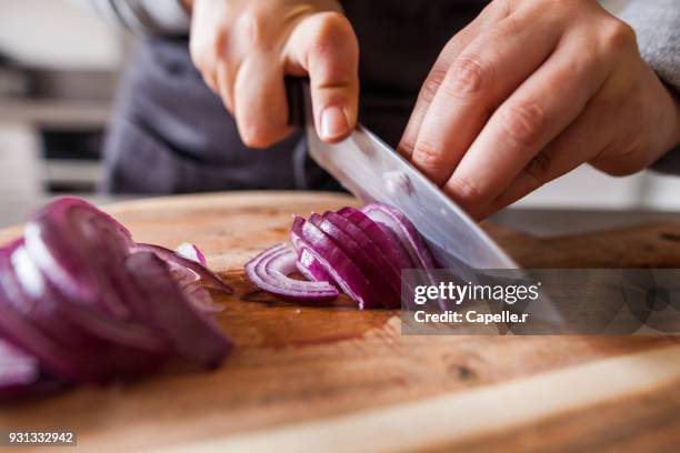 cuisiner - découpe d'oignons rouges - chopping stock pictures, royalty-free photos & images