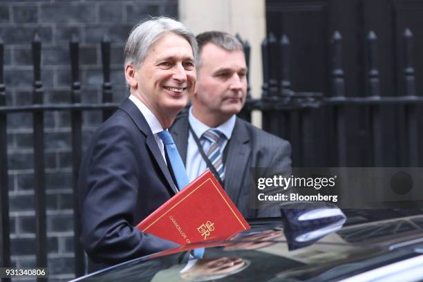 Philip Hammond, U.K. Chancellor of the exchequer, left, leaves number 11 Downing Street to present the Spring Statement in Parliament in London,...