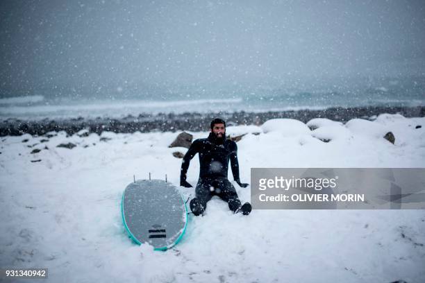 Leela Krischna from India takes a rest after a surfing session, on March 11 in Unstad, northern Norway, Lofoten islands, within the Arctic Circle as...