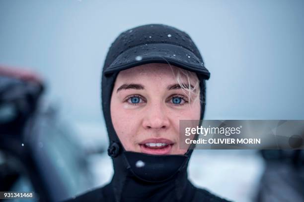 Emilie Klerud from Norway poses after a surf session, on March 11 in Unstad northern Norway, Lofoten islands, within Arctic Circle as air temperature...