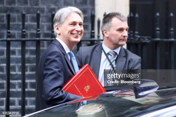 Philip Hammond, U.K. Chancellor of the exchequer, left, leaves number 11 Downing Street to present the Spring Statement in Parliament in London,...
