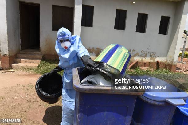 Health official wears protective gear to empty medical waste used for treating Lassa fever patients at the Institute of Lassa Fever Research and...