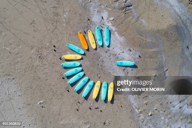 Surfboards lay on a beach before a surf lesson on March 10, 2018 in Unstad, northern Norway, Lofoten islands, within the Arctic Circle as air...