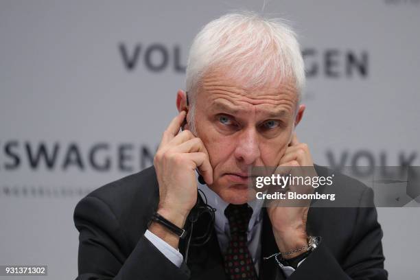 Matthias Mueller, chief executive officer of Volkswagen AG , holds his earpieces during a news conference at the automaker's annual media conference...