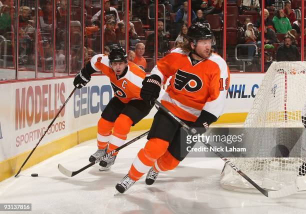 Mike Richards of the Philadelphia Flyers skates with the puck behind teammate Scott Hartnell against the Ottawa Senators at the Wachovia Center on...
