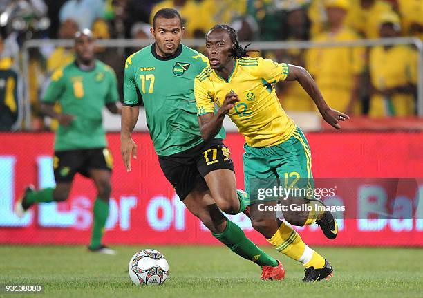 Reneilwe Letsholonyane of South Africa is chased by Rodolph Austin of Jamaica during the International Friendly match between South Africa and...