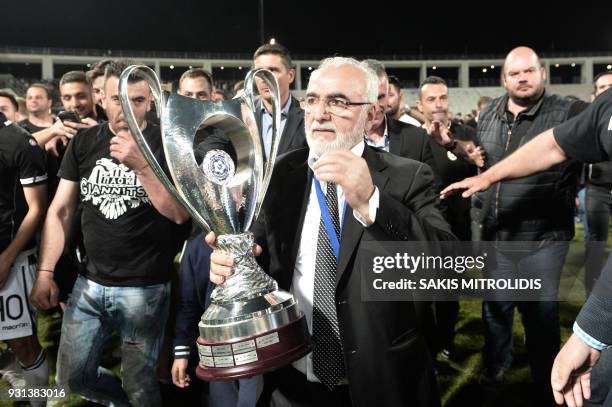 Picture taken on May 6 shows PAOK's Greek-Russian president Ivan Savvidis holding the trophy after the cup-final match between PAOK Thessaloniki and...