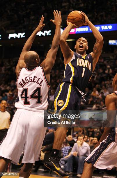 Dahntay Jones of The Indiana Pacers shoots over Trenton Hassell of the New Jersey Nets during their game on November 17, 2009 at The Izod Center in...