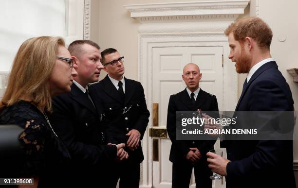 Britain's Prince Harry talks with Metropolitan Police officers as he and Britain's Prince William, Duke of Cambridge host the winners of The Met...