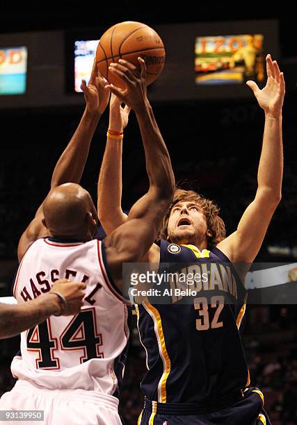 Josh McRoberts of The Indiana Pacers and Trenton Hassell of the New Jersey Nets go for a rebound during their game on November 17, 2009 at The Izod...