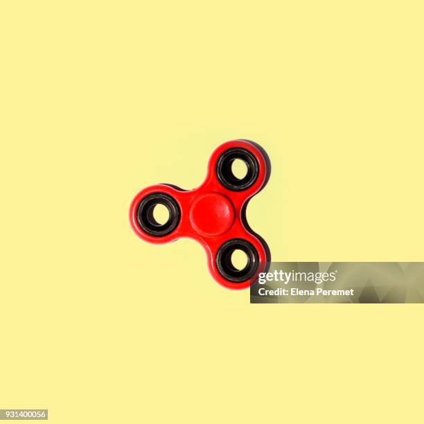 red spinner on a pale yellow background - adhd medication stockfoto's en -beelden