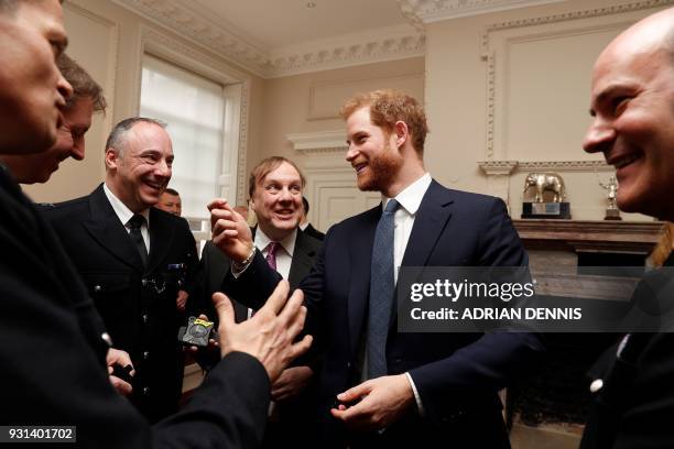 Britain's Prince Harry talks with Metropolitan Police officers as he and Britain's Prince William, Duke of Cambridge host the winners of The Met...