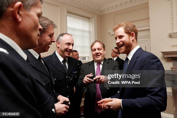 Prince Harry talks with Metropolitan Police officers as he and Prince William, Duke of Cambridge host the winners of The Met Excellence Awards at...