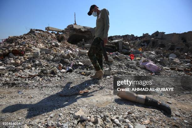 An Iraqi man walks past a prosthetic leg in a residential area in the Old City of Mosul on March 13 eight months after Iraqi forces liberated the...