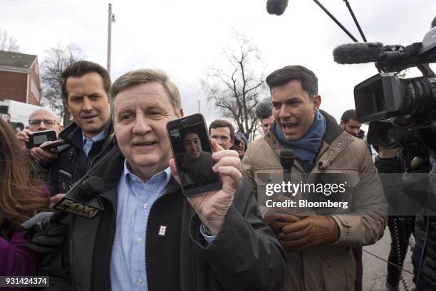 Rick Saccone, Republican candidate for the U.S. House of Representatives, holds a smartphone while speaking to members of the media after voting at...