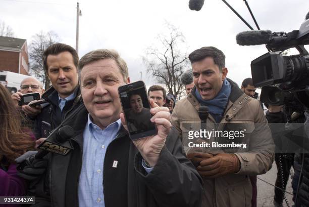 Rick Saccone, Republican candidate for the U.S. House of Representatives, holds a smartphone while speaking to members of the media after voting at...