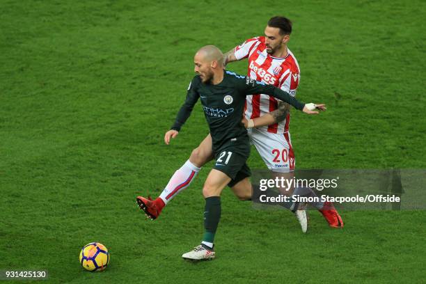 Geoff Cameron of Stoke battles with David Silva of Man City during the Premier League match between Stoke City and Manchester City at the Bet365...