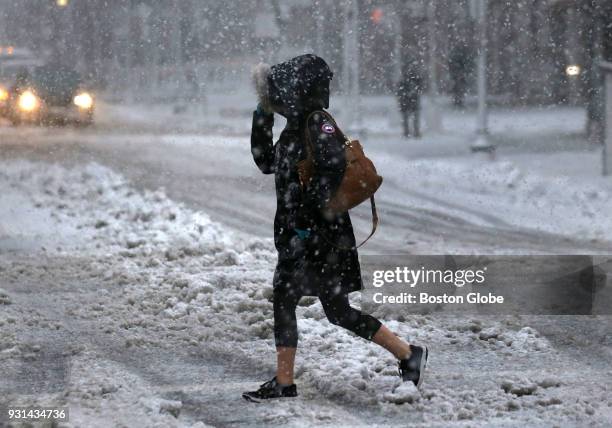 Pedestrian crosses Boylston Street in Boston as snow falls during the third nor'easter storm to hit the region in two weeks on March 13, 2018.