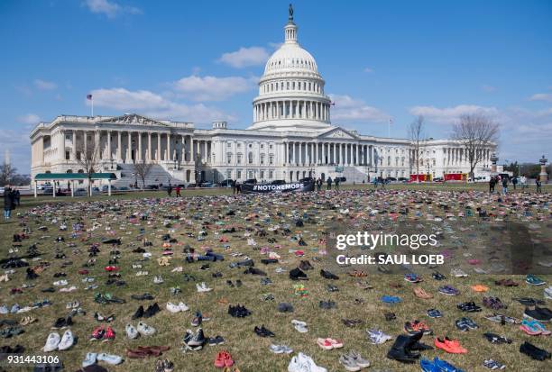 The lawn outside the US Capitol is covered with 7,000 pairs of empty shoes to memorialize the 7,000 children killed by gun violence since the Sandy...