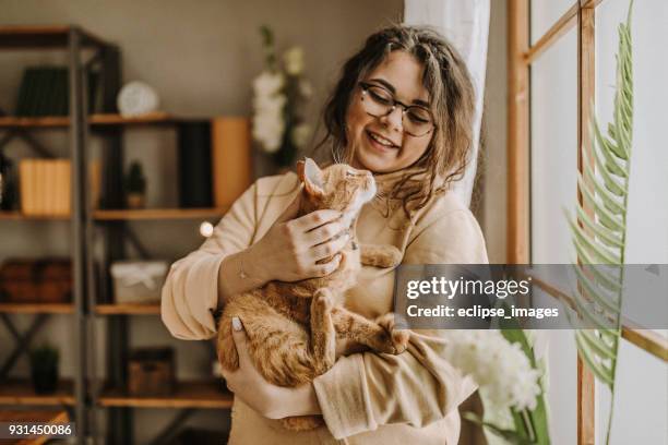 carefree woman with cat - cat woman stock pictures, royalty-free photos & images