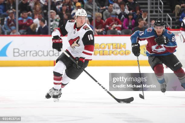 Christian Dvorak of the Arizona Coyotes skates ahead of Matt Nieto of the Colorado Avalanche at the Pepsi Center on March 10, 2018 in Denver,...