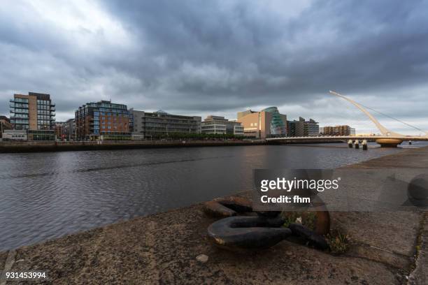 samuel beckett bridge in dublin with liffey river and city skyline (dublin/ ireland) - convention centre dublin stock pictures, royalty-free photos & images