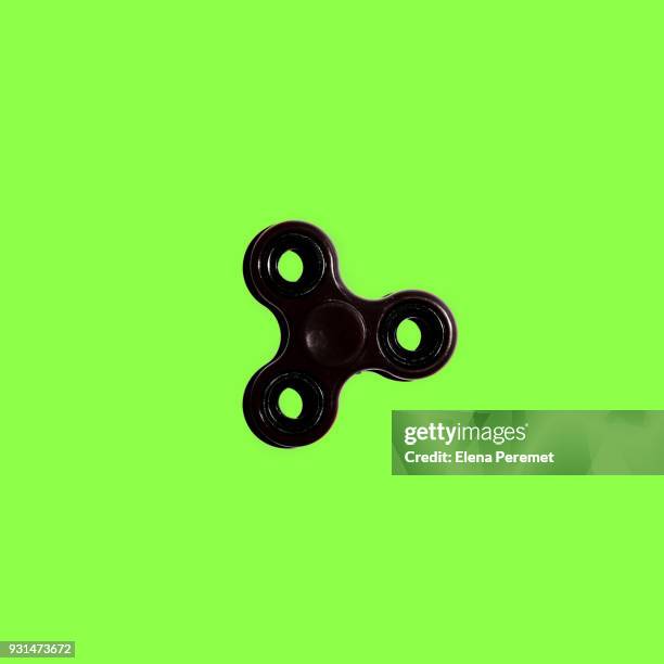 black spinner on bright green background - gegengift stock-fotos und bilder