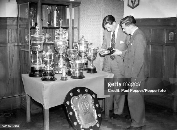 Chelsea manager Ted Drake with the club's programme editor Albert Sewell looking at trophies in the boardroom at Stamford Bridge in London, 21st June...
