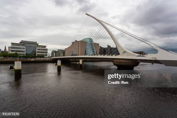 samuel beckett bridge in dublin with liffey river and city skyline (dublin/ ireland) - convention centre dublin stock pictures, royalty-free photos & images