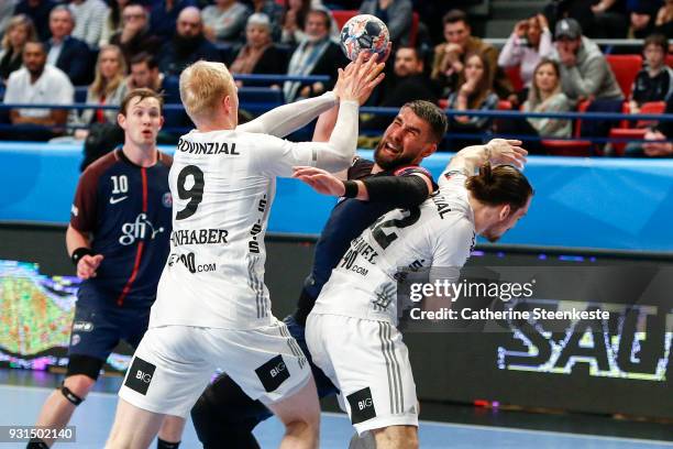 Luka Karabatic of Paris Saint Germain is trying to shoot the ball against Sebastian Firnhaber and Ole Rahmel of THW Kiel during the Champions League...