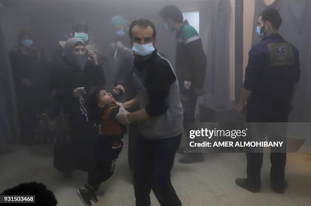 Syrian civilians arrive at a makeshift clinic during Syrian government air strikes on Zamalka, in the rebel enclave of Eastern Ghouta on the...