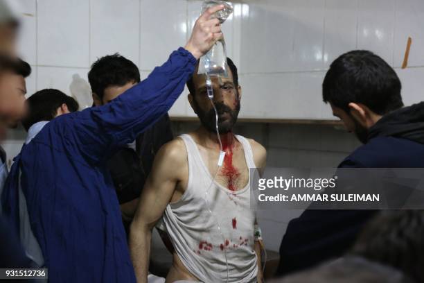 Wounded Syrian man receives treatment at a make shift hospital following government bombardment in Kafr Batna in the rebel-held enclave of Eastern...